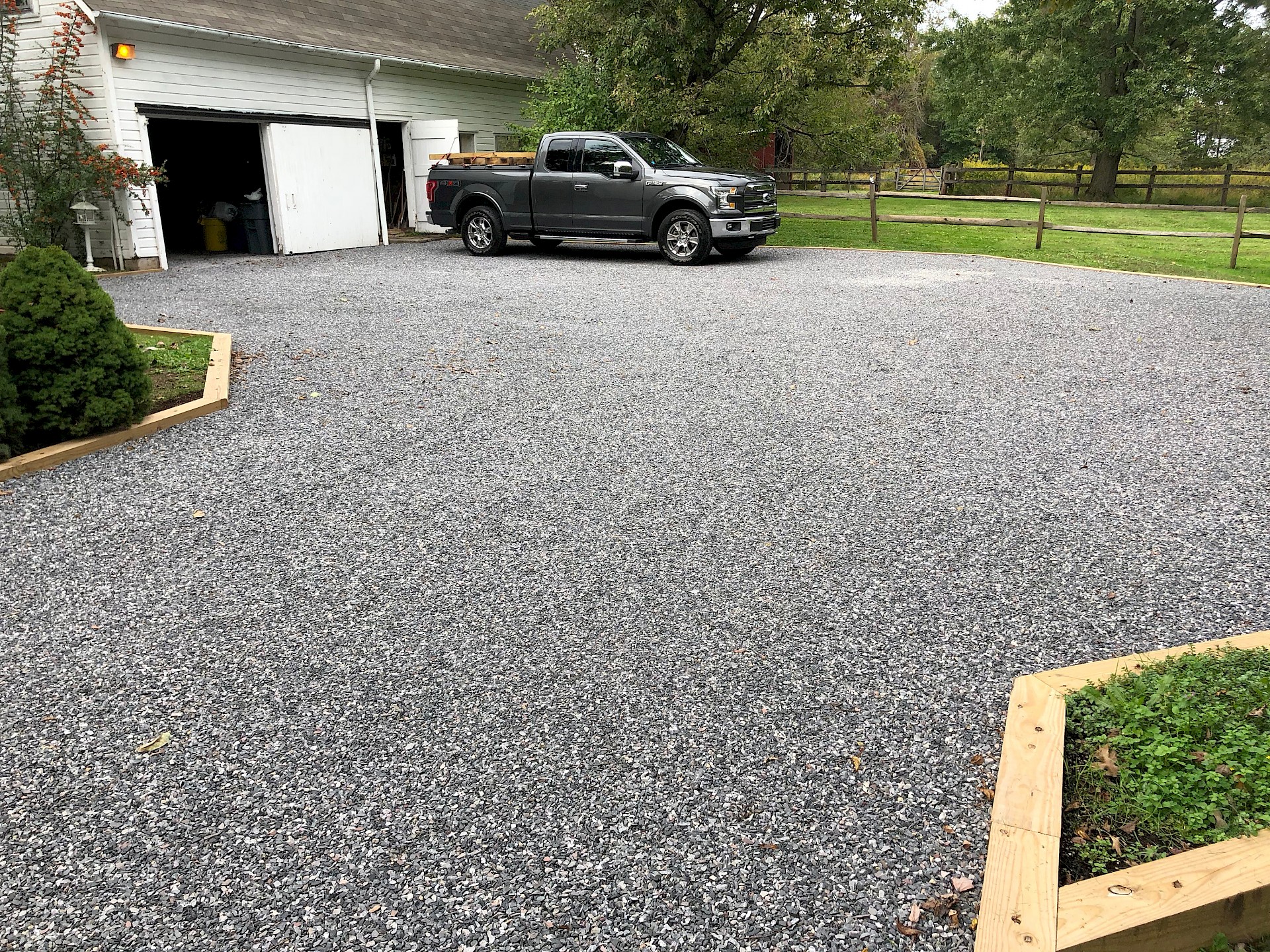 Newly installed gravel driveway by Cypress Ridge Land Management near me, showcasing smooth surface and truck parked.